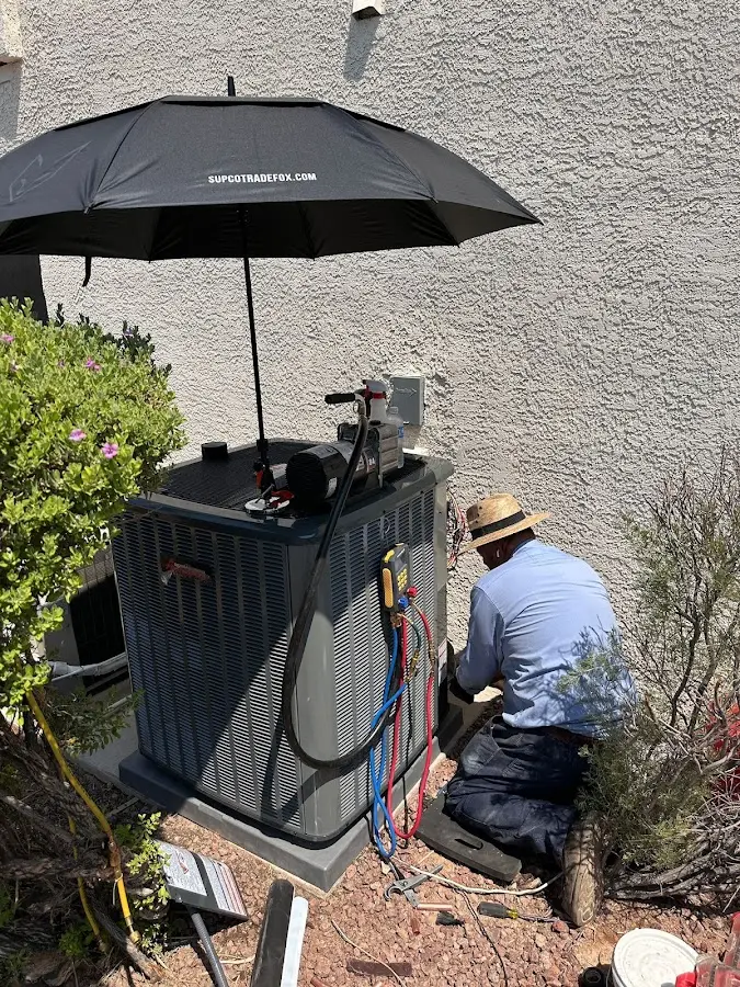 HVAC technician performing outdoor AC maintenance in Muskogee